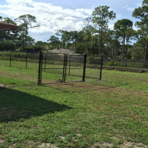 6 ft. black vinyl chain link fence installation with double drive gate.